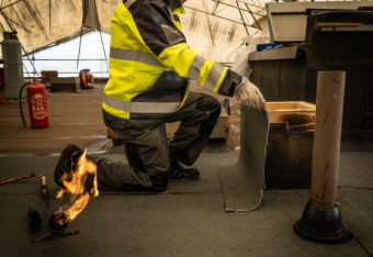 Mies tekee tulitöitä katolla.