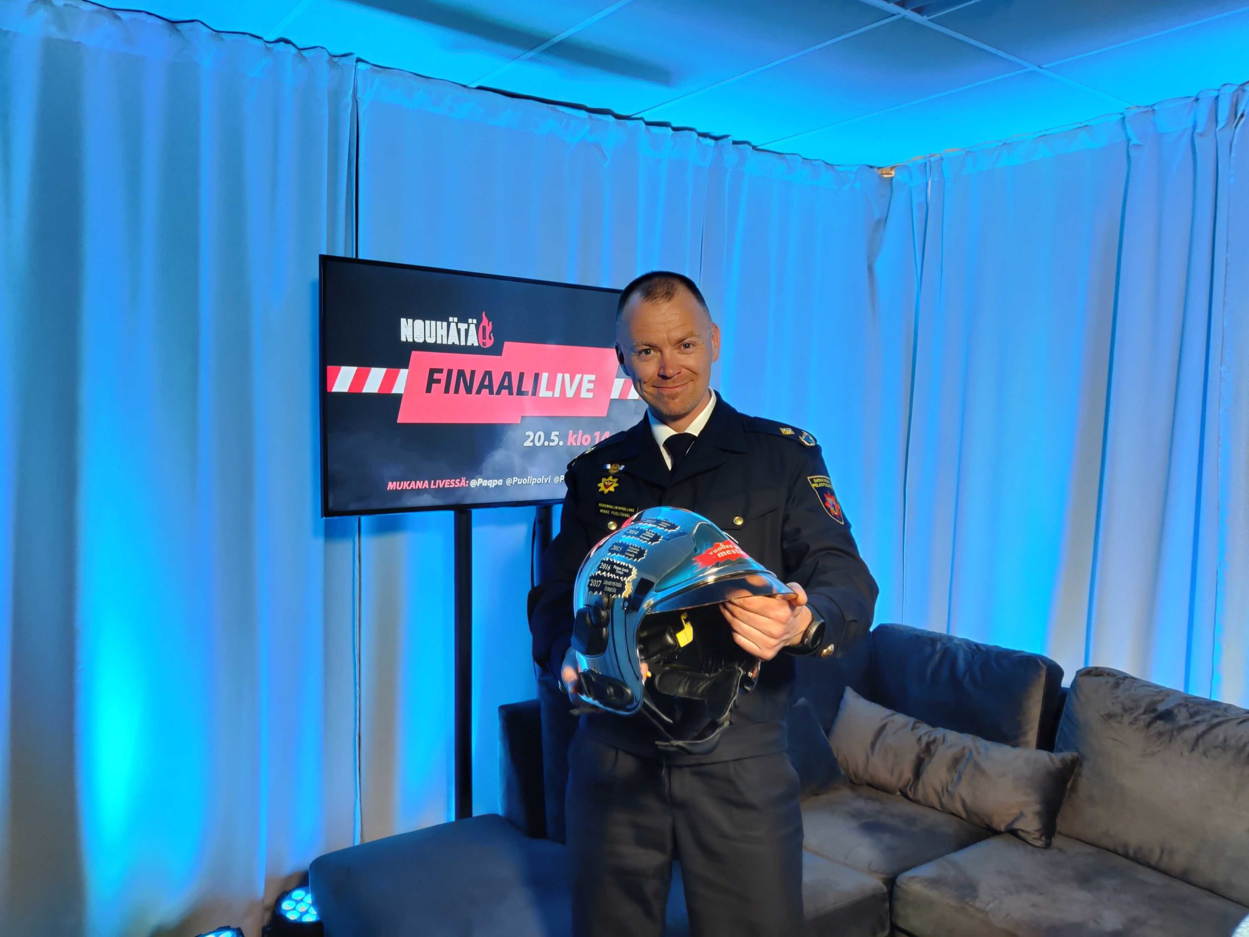 Mikko Puolitaival ojentaa palkintokypärää.