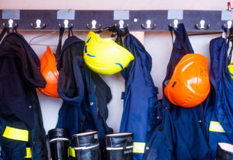 Pelastajien vaatteita ja varusteita pukuhuoneen naulakossa.