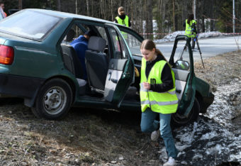 NouHätä!-joukkue auttaa loukkaantunutta henkilöä auto-onnettomuudessa.