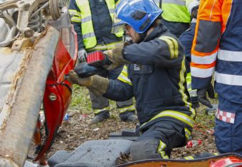Palokuntalainen avaa romuttunutta autoa auki.