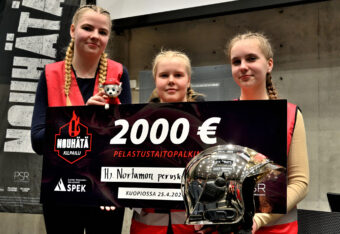 NouHätä!-finaalin voittajajoukkue poseeraa palkintoshekin ja palkintokypärän kanssa.