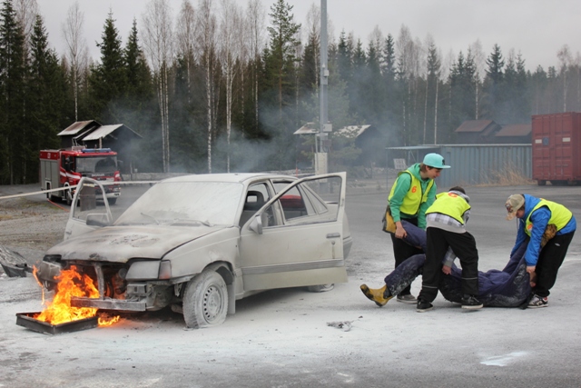 Nuoret harjoittelevat ihmisen pelastamista palavasta autosta.