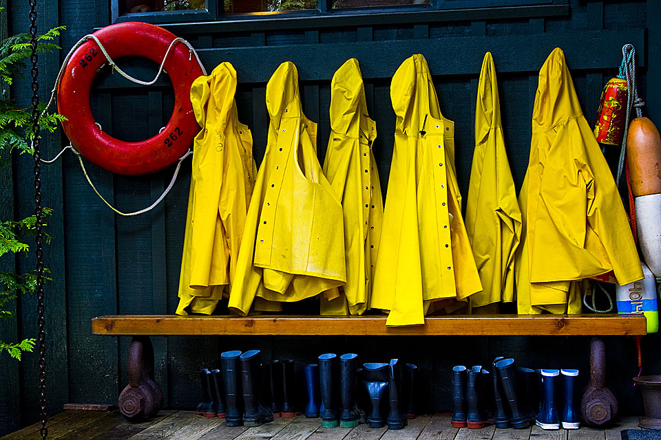 Sadetakkeja ja pelastusrengas roikkumassa naulakossa.