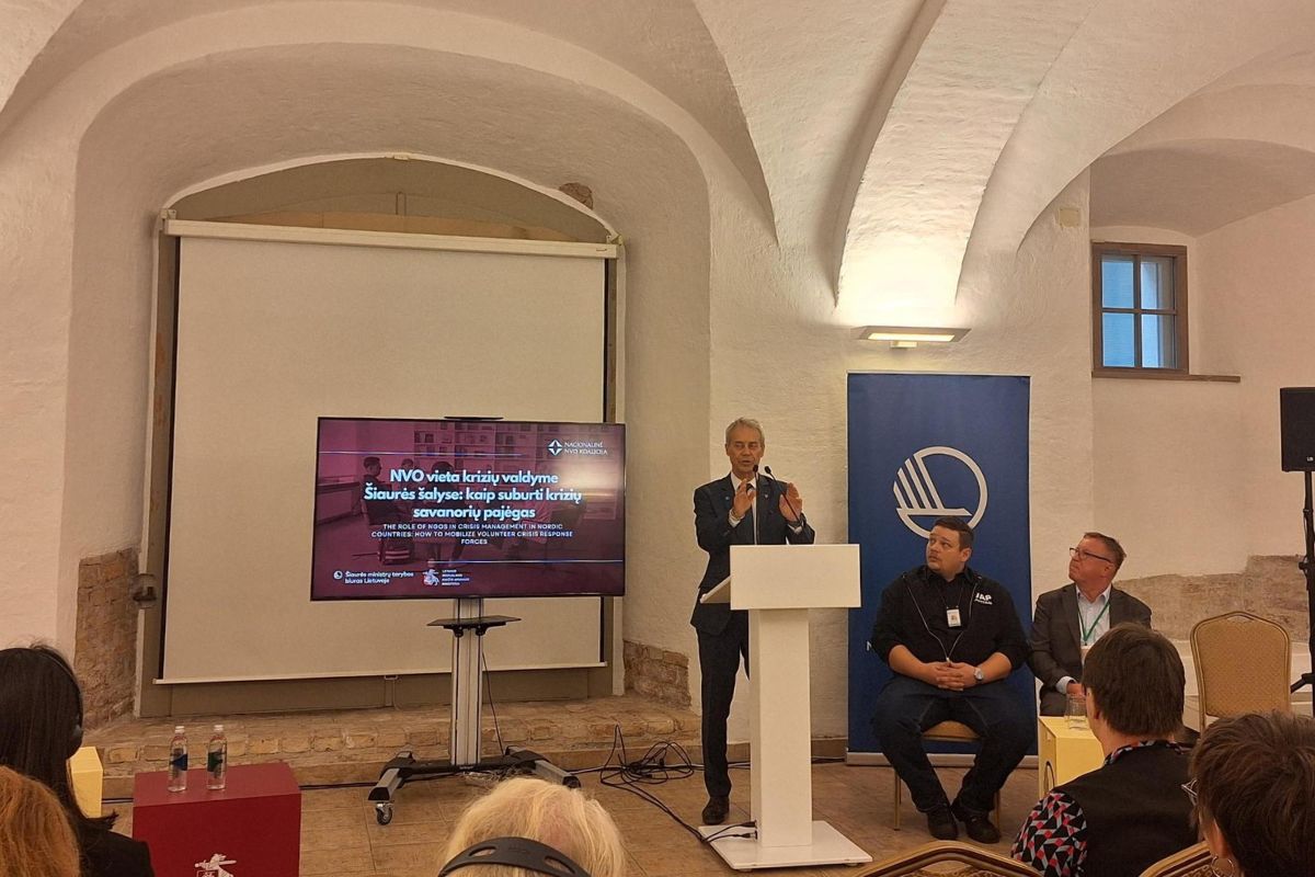 Mies pitää esitystä puhujanpöntössä ja yleisö seuraa.