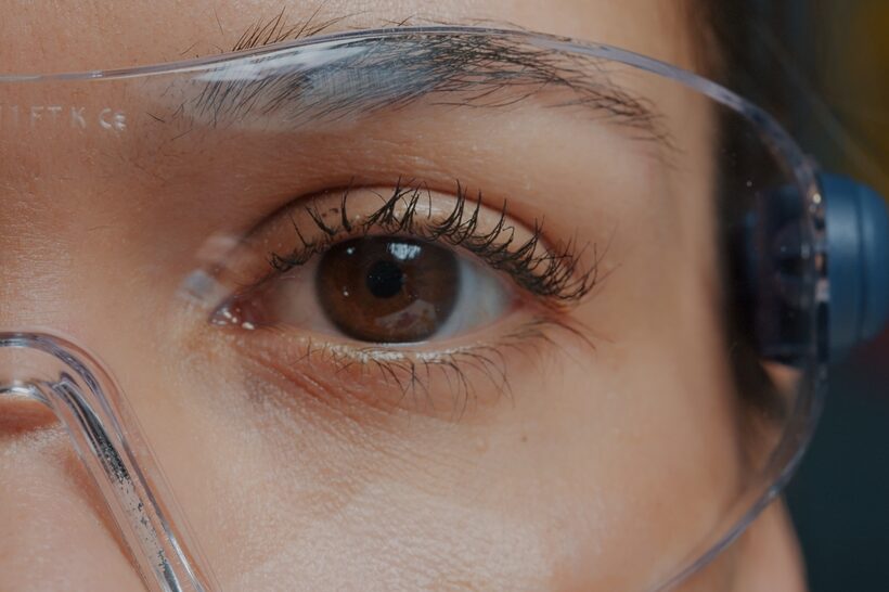 Brown eyes with makeup, protected by safety goggles.