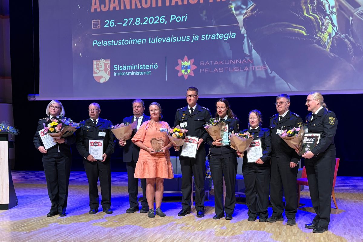 NouHätä-palkinnon saajat seisovat rivissä lavalla palkintopystit ja kukkakimput kädessä.